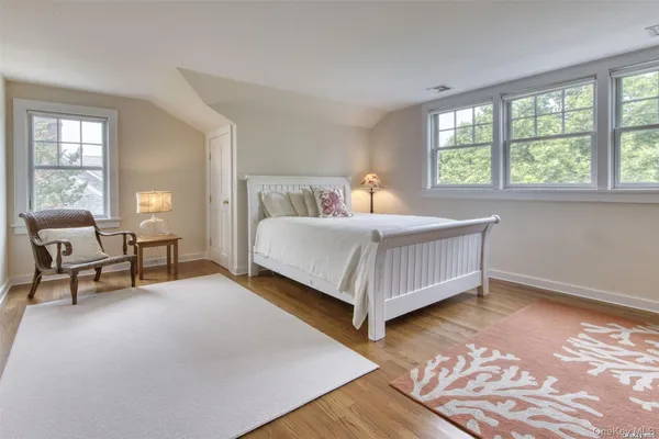 a bedroom with a bed chair and a window