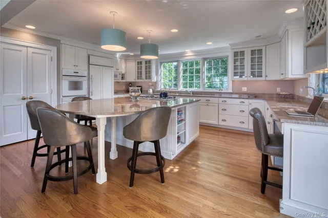 a kitchen with stainless steel appliances granite countertop refrigerator dining table and chairs
