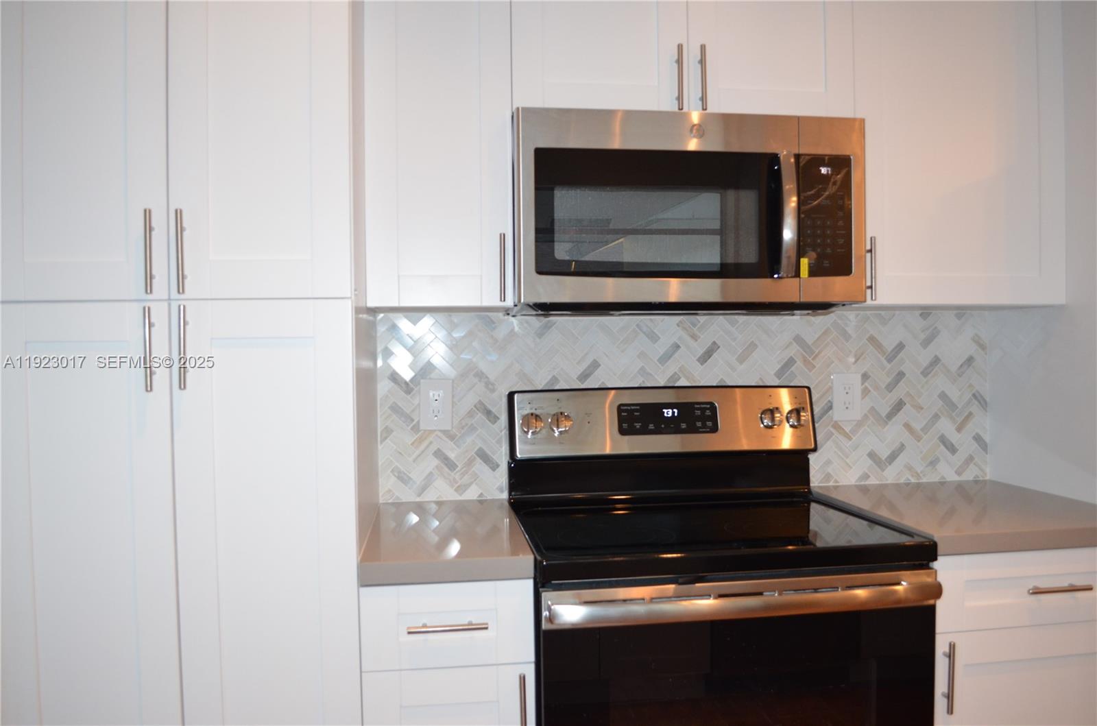 13491 Southwest 99th Terrace Miami, FL 33186 - Photo 16 of 41 a kitchen with a stove and a microwave
