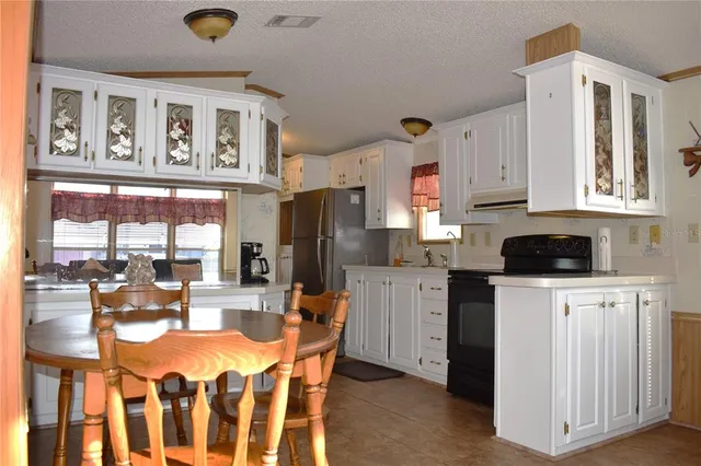 a kitchen with stainless steel appliances kitchen island granite countertop a refrigerator and microwave