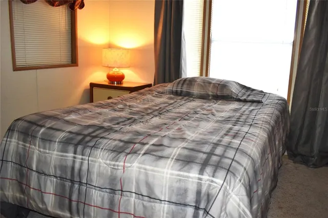 a bedroom with a bed and a window