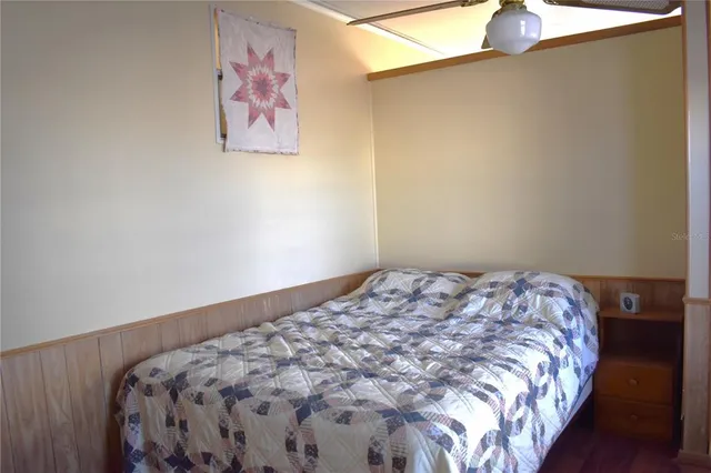 a bedroom with a bed and a painting on the wall