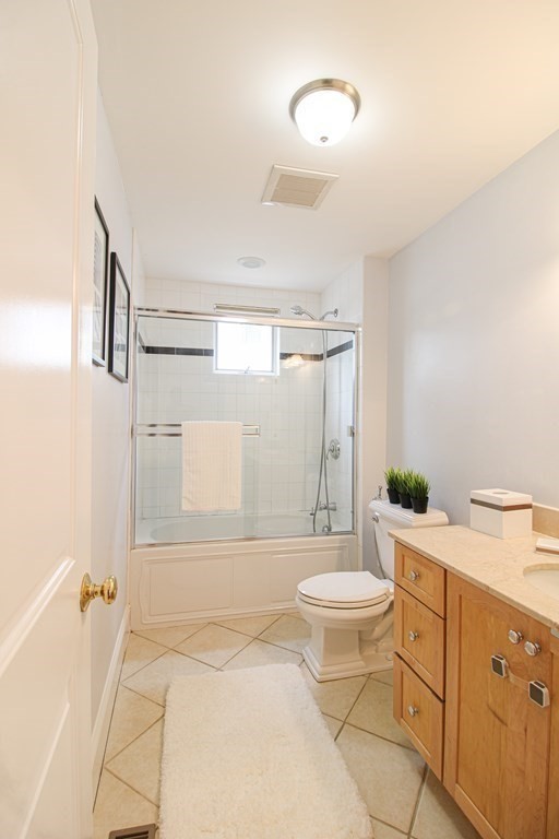 10 Marlboro Street, Unit 1 Belmont, MA 02478 - Photo 13 of 20 a bathroom with a granite countertop sink toilet a mirror and bathtub