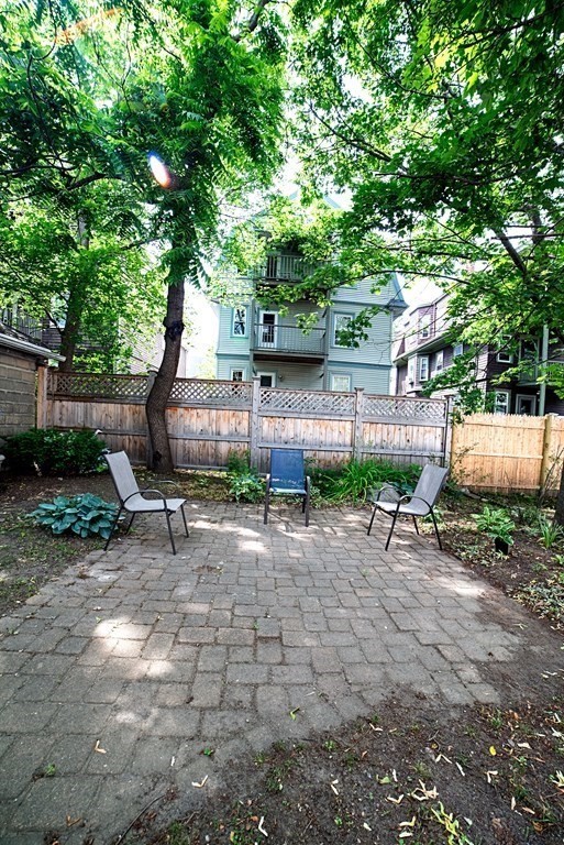 10 Marlboro Street, Unit 1 Belmont, MA 02478 - Photo 18 of 20 a backyard of a house with barbeque oven table and chairs