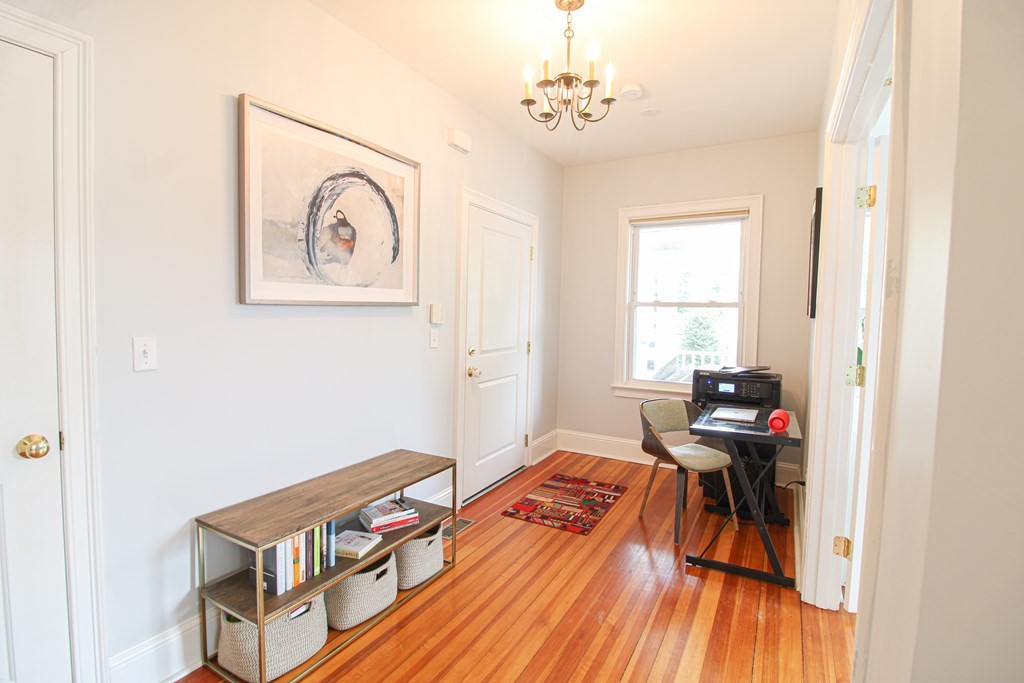 10 Marlboro Street, Unit 1 Belmont, MA 02478 - Photo 2 of 20 a bedroom with a bed and wooden floor