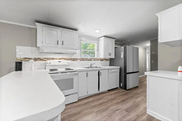 a kitchen with a sink cabinets stainless steel appliances and a window