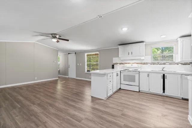 a kitchen with granite countertop white cabinets and white appliances