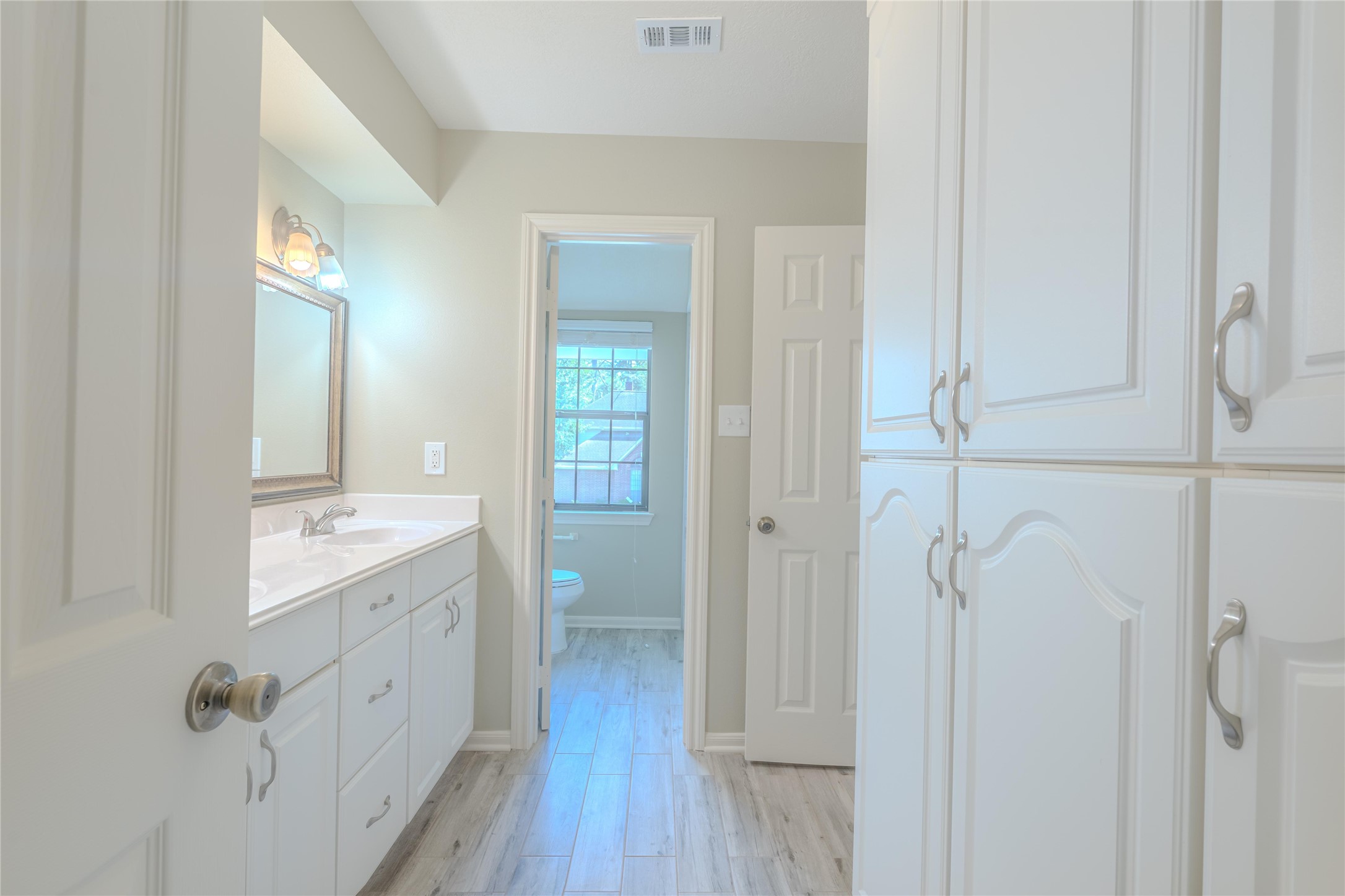 5938 Theall Road Houston, TX 77066 - Photo 23 of 35 a spacious bathroom with a double vanity sink a toilet and a mirror