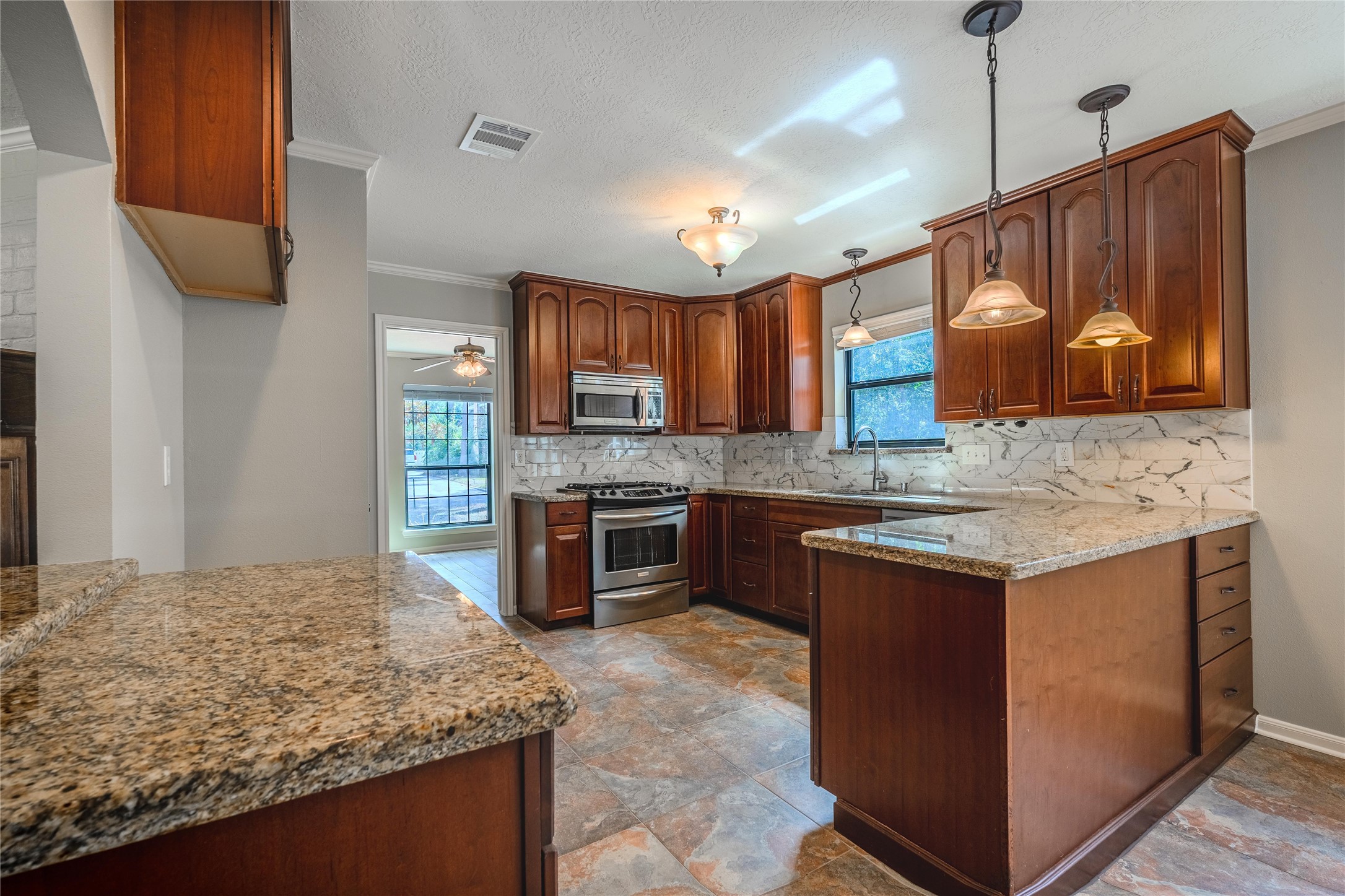 5938 Theall Road Houston, TX 77066 - Photo 10 of 35 a kitchen with granite countertop a stove cabinets and refrigerator