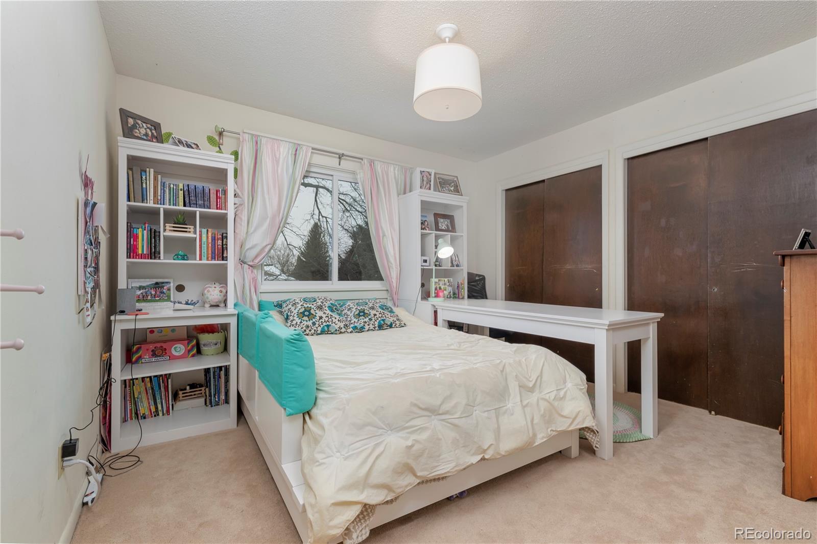 643 Furman Way Boulder, CO 80305 - Photo 13 of 25 a bedroom with a bed table and a chandelier