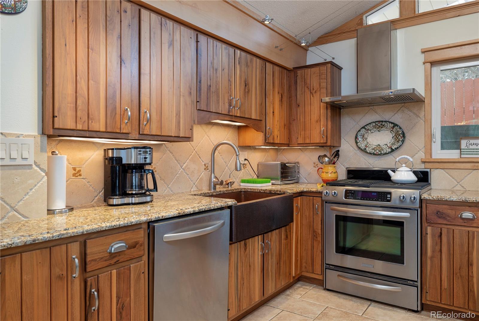 643 Furman Way Boulder, CO 80305 - Photo 6 of 25 a kitchen with granite countertop a stove top oven sink and cabinets