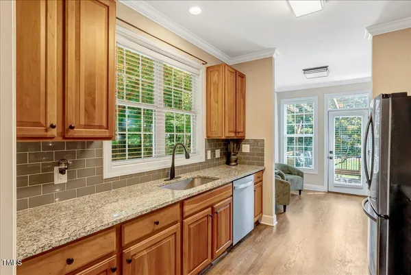 a kitchen with granite countertop a sink a counter top space and cabinets