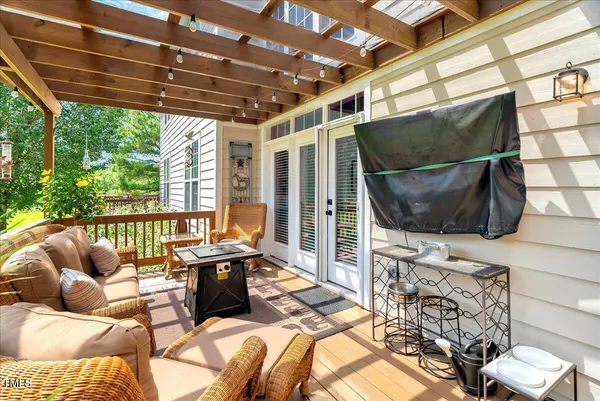 a living room with furniture a flat screen tv and a floor to ceiling window