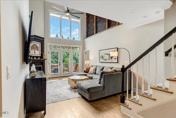 a living room with furniture a floor to ceiling window and a flat screen tv