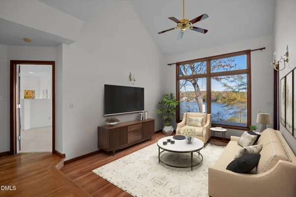 a living room with furniture a flat screen tv and a large window