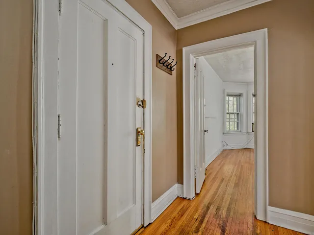 a view of a hallway with wooden floor and closet