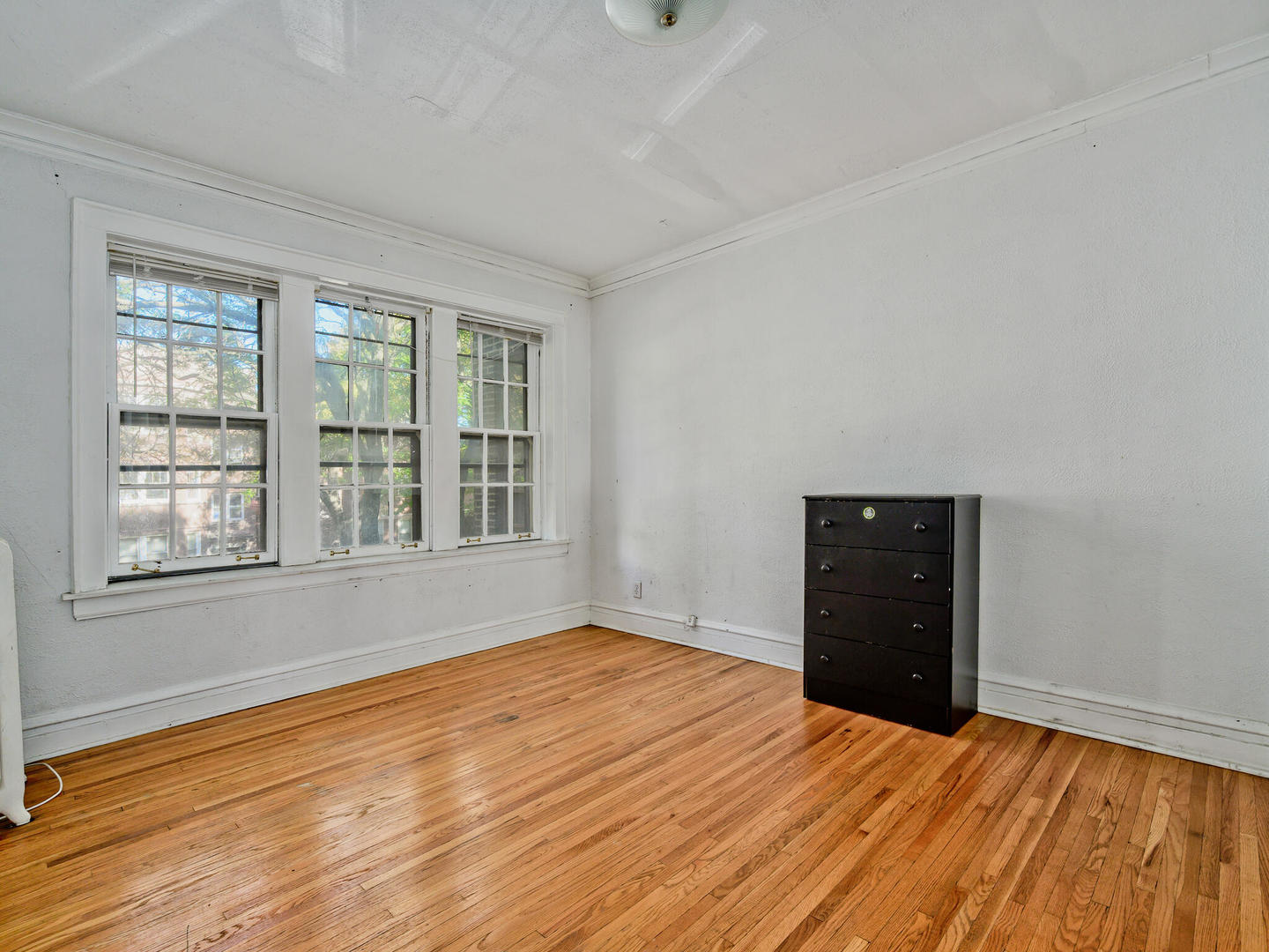 6457 North Bell Avenue, Unit 2 Chicago, IL 60645 - Photo 10 of 14 a view of an empty room with a window and wooden floor