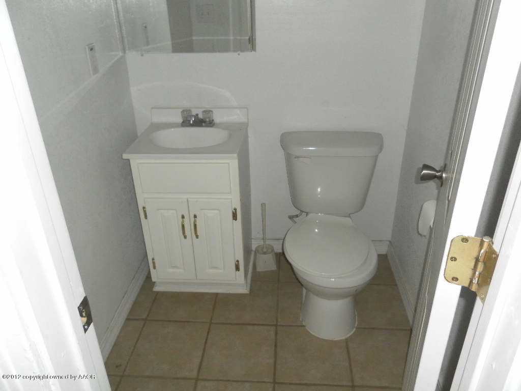 4313 South Polk Street Amarillo, TX 79110 - Photo 5 of 10 a bathroom with a toilet sink and mirror