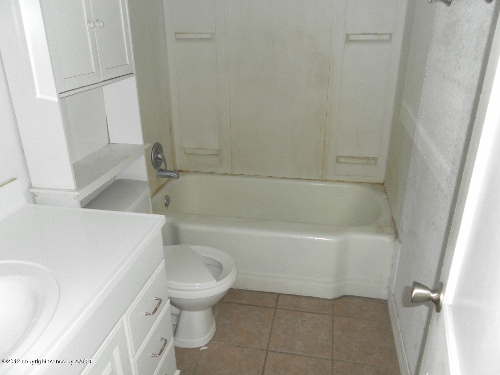 4313 South Polk Street Amarillo, TX 79110 - Photo 6 of 10 a white bath tub sitting next to a white toilet