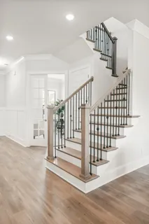 a view of staircase with lots of frames and white walls
