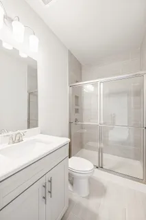 a bathroom with a sink a toilet and shower