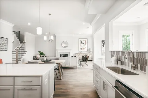 a open kitchen with stainless steel appliances kitchen island a white counter space a sink and living room view