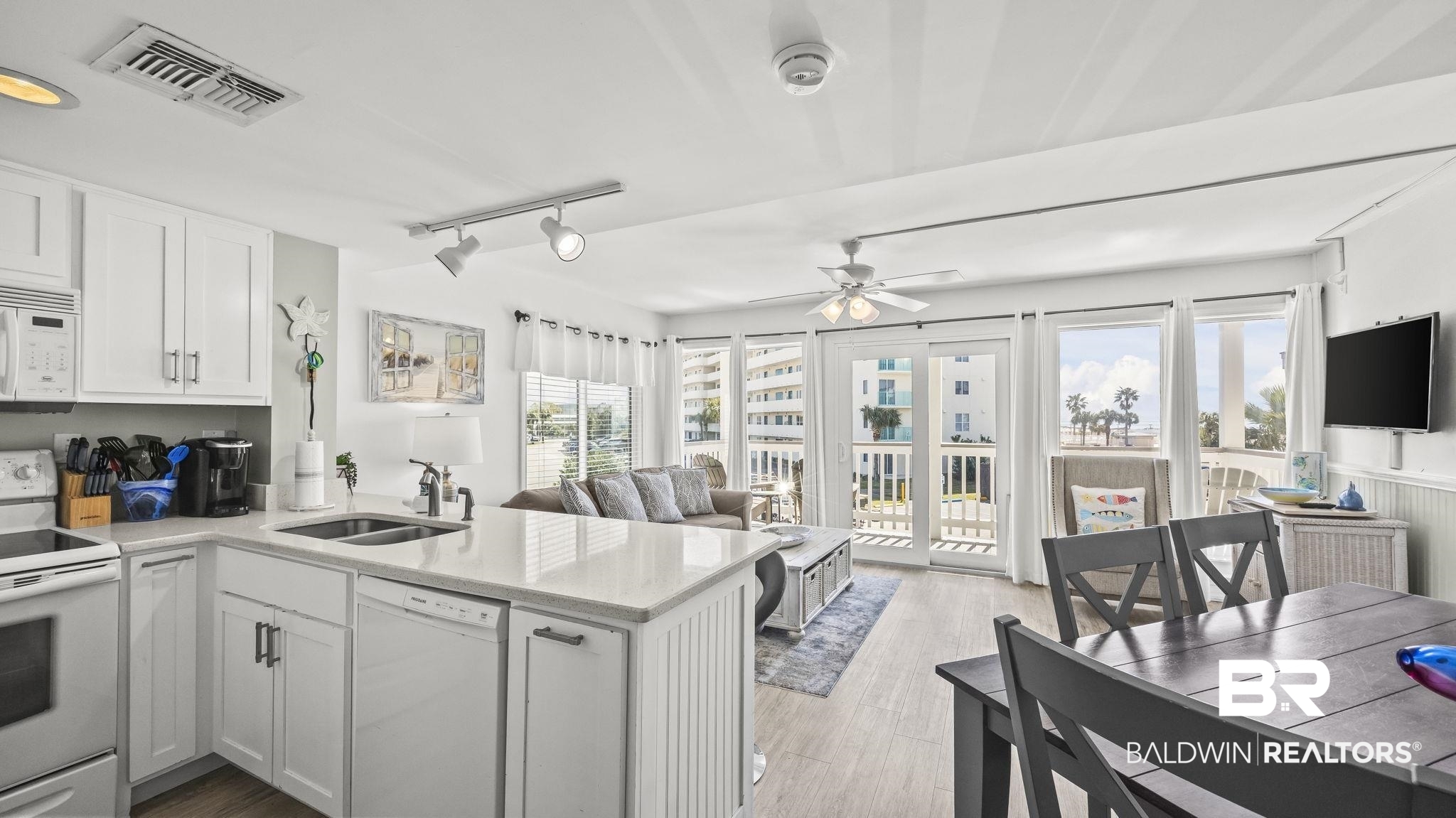 497 Plantation Road, Unit 1247 Gulf Shores, AL 36542 - Photo 28 of 29 Kitchen with white appliances, a peninsula, white cabinetry, open floor plan, and track lighting