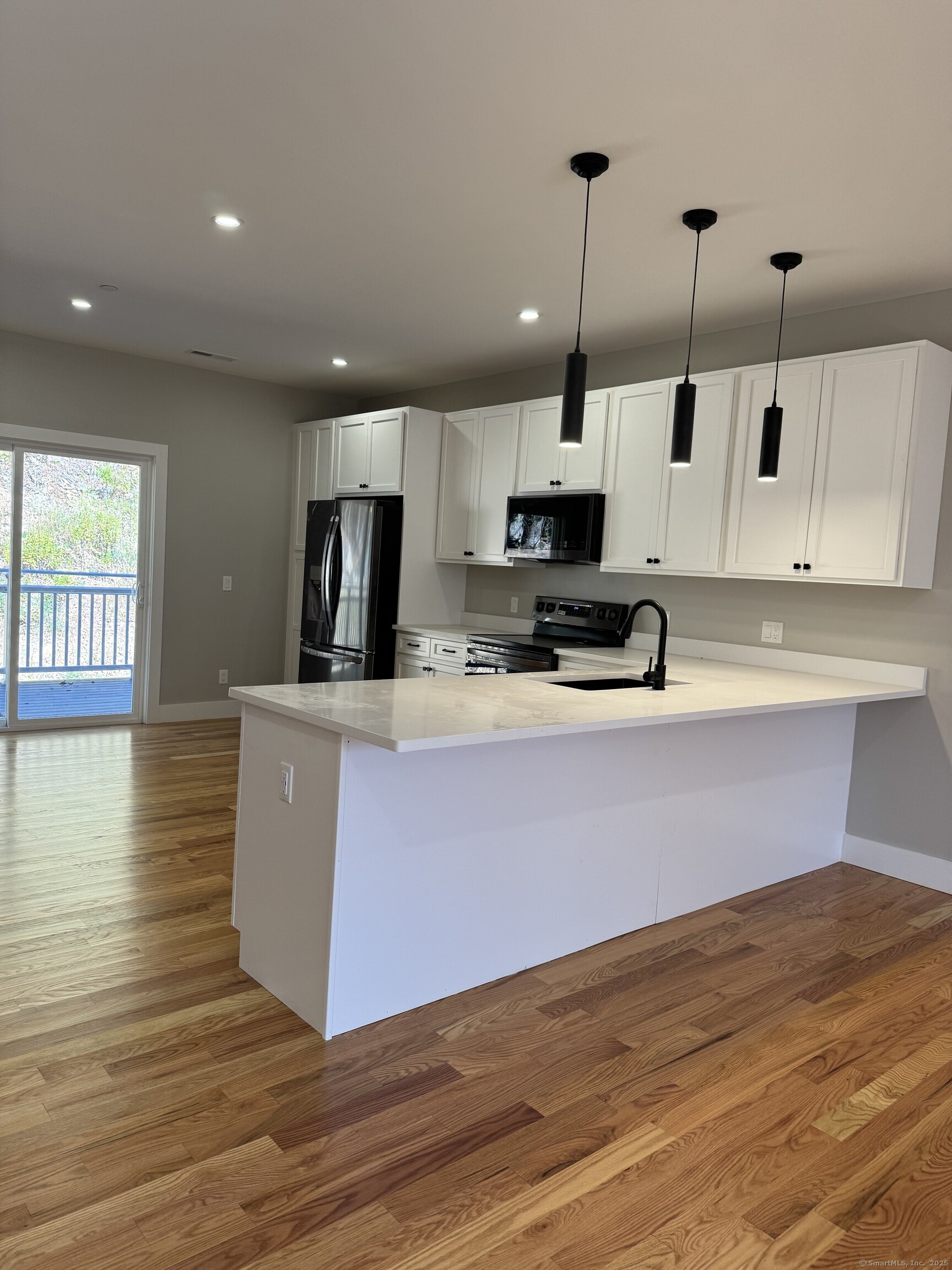 243 Echo Lake Road, Unit B8 Watertown, CT 06795 - Photo 1 of 11 a kitchen with kitchen island granite countertop a stove a sink a microwave and wooden floors