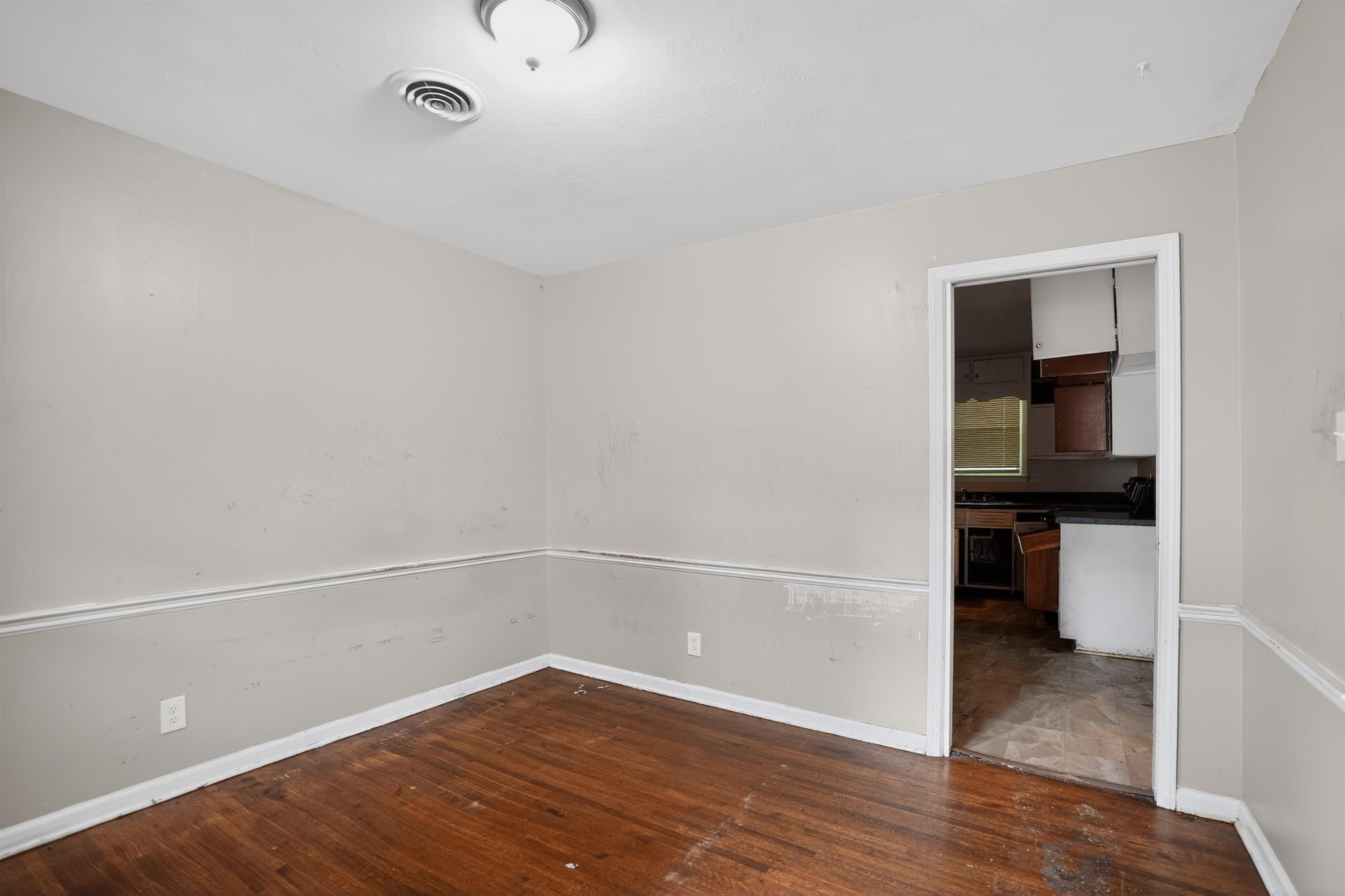 1890 Pennel Road Memphis, TN 38116 - Photo 12 of 25 Room featuring wood-finish flooring, two-tone painted walls with chair rail molding, and a flush mount ceiling light