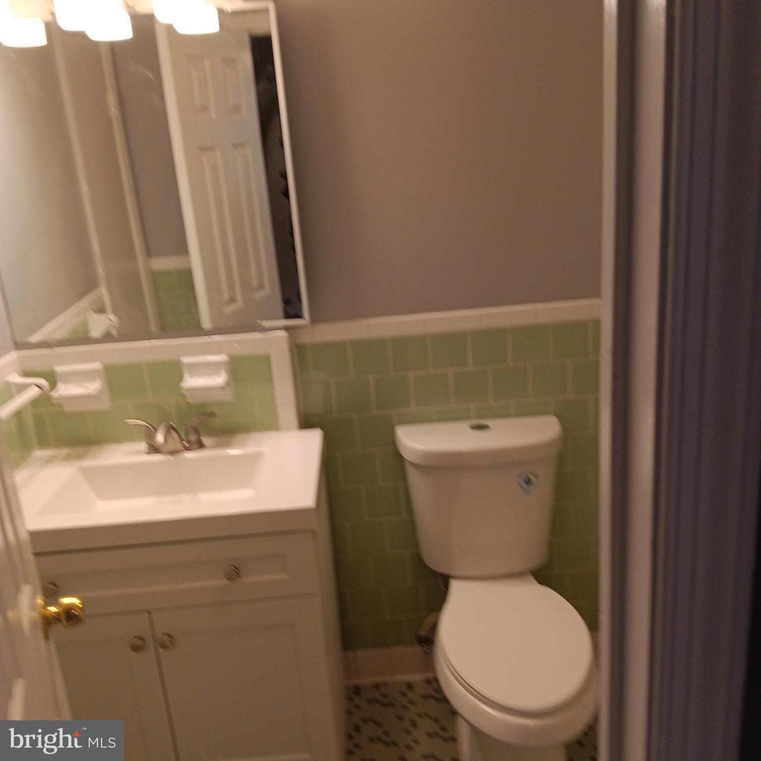 1971 Addison Road South District Heights, MD 20747 - Photo 11 of 30 a bathroom with a sink a toilet and a mirror