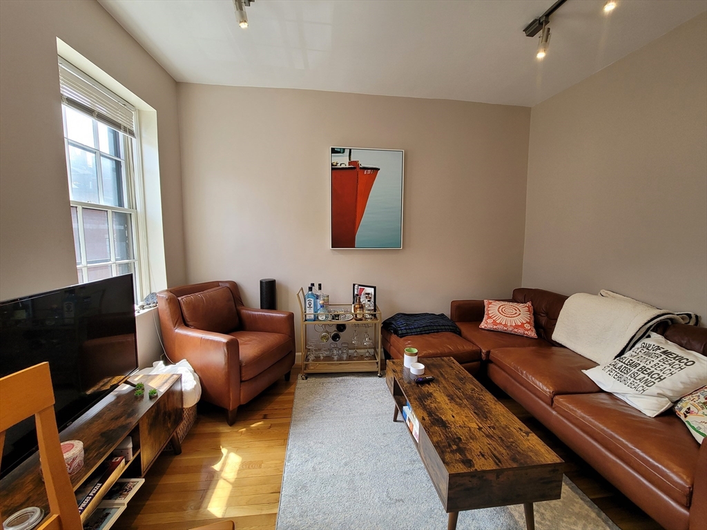 11 Phillips Street, Unit 8 Boston, MA 02114 - Photo 2 of 14 a living room with furniture a flat screen tv and a window