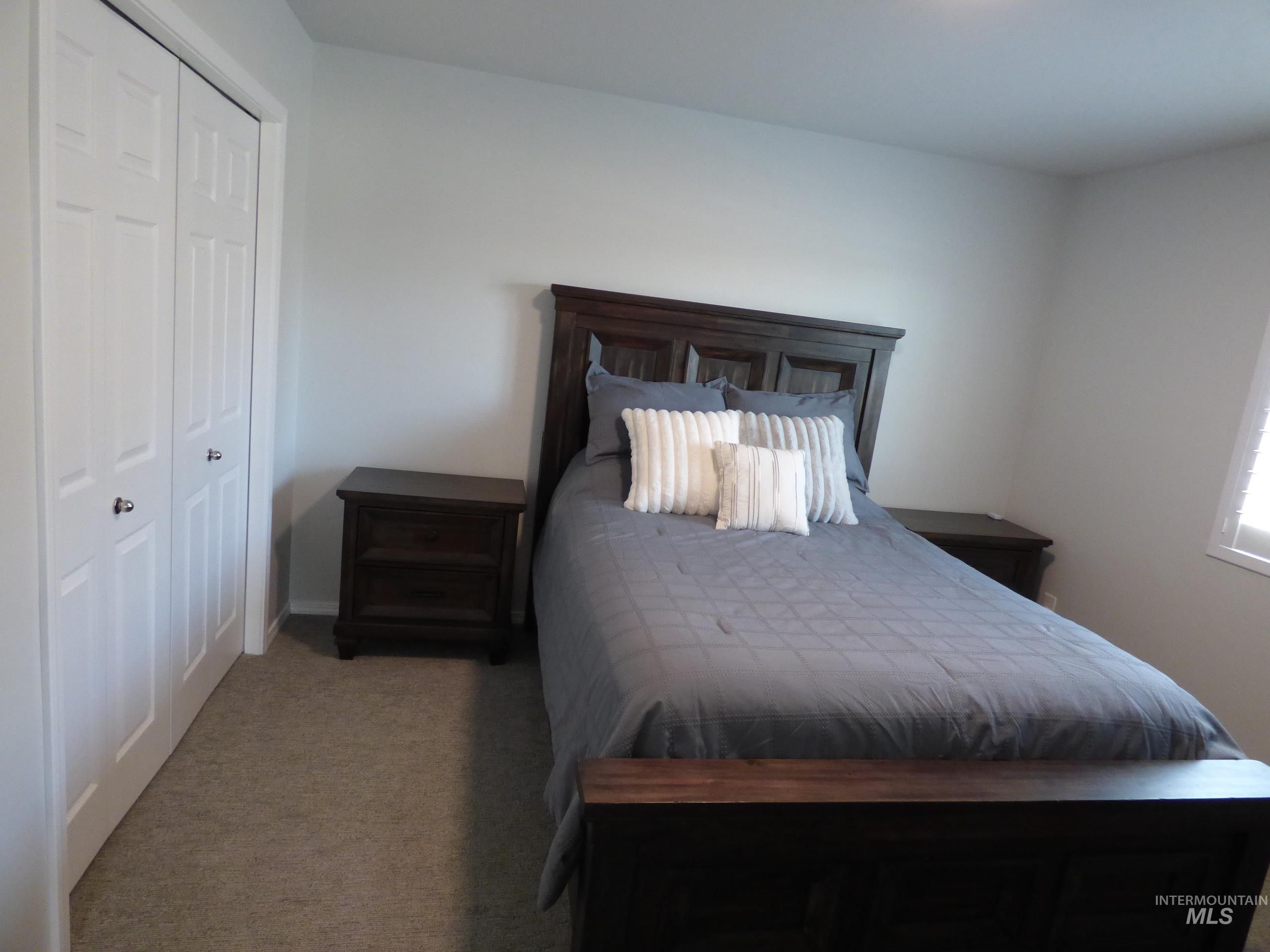 2708 East Buckaroo Drive Kuna, ID 83634 - Photo 29 of 48 Neutral tone wall paint with a window, white bi-fold closet doors, and carpet flooring