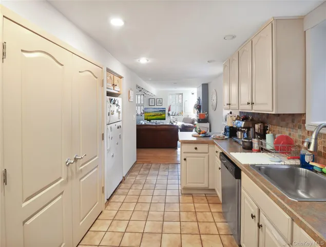 a kitchen with a sink a refrigerator and cabinets