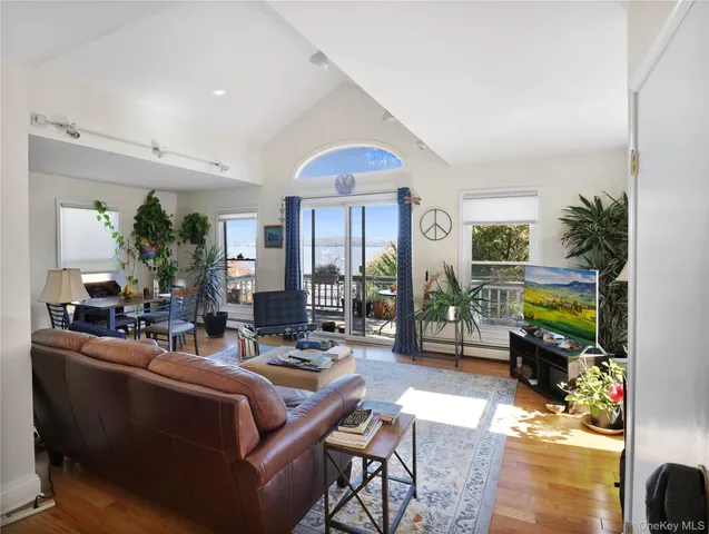 a living room with furniture a fireplace and a floor to ceiling window