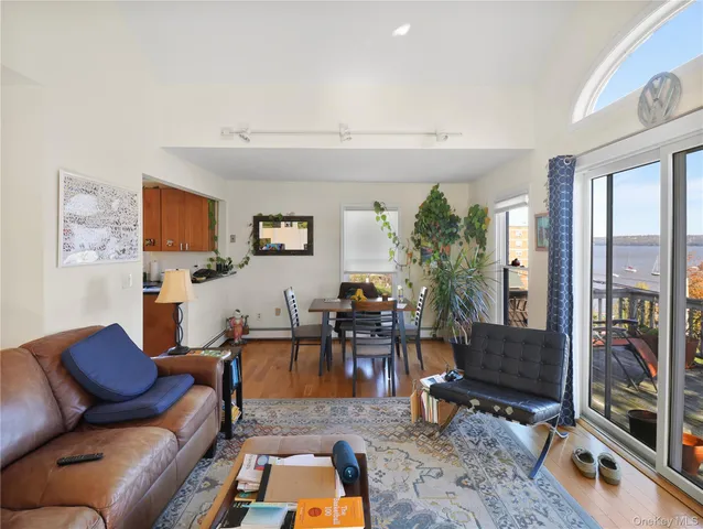 a living room with furniture a flat screen tv and a floor to ceiling window