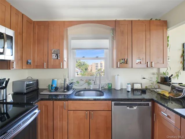 a kitchen with stainless steel appliances granite countertop a sink stove and cabinets
