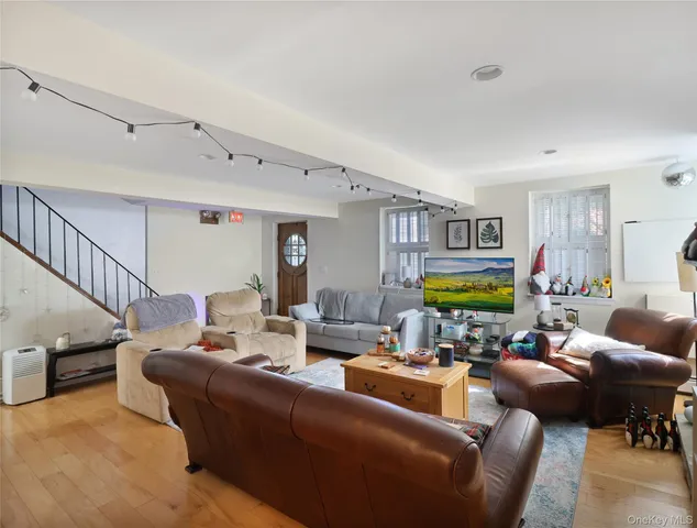 a living room with furniture kitchen view and a window