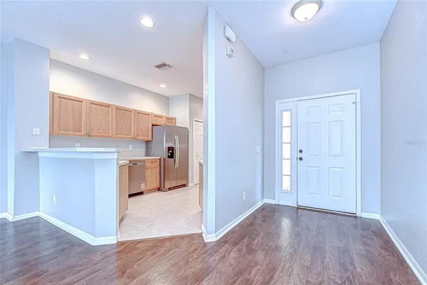 a kitchen with stainless steel appliances a sink a refrigerator and white cabinets