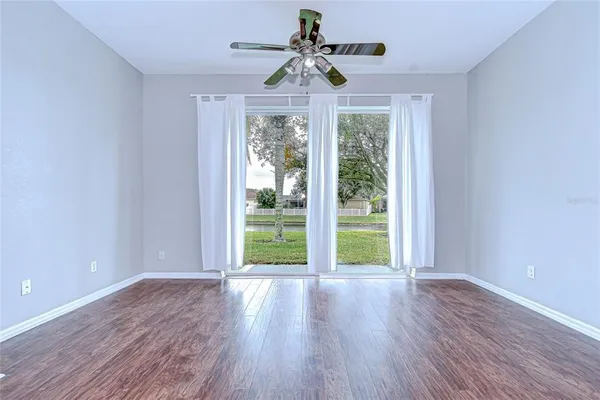 a view of a hallway with wooden floor and a cabinet