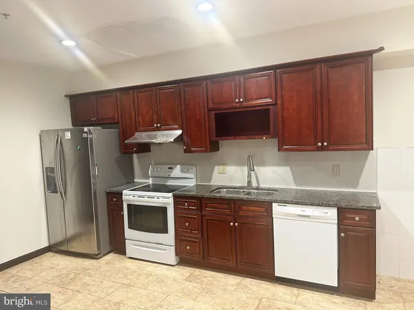 a kitchen with stainless steel appliances granite countertop a stove a refrigerator and a sink