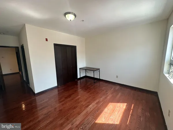 an empty room with wooden floor and a window