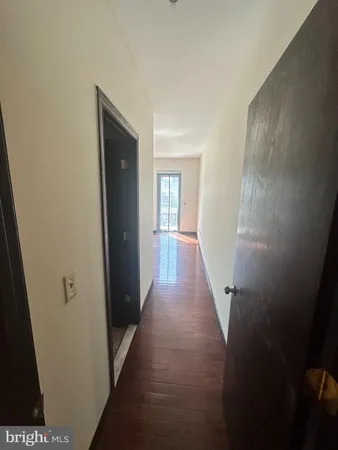 a view of a hallway with wooden floor and closet