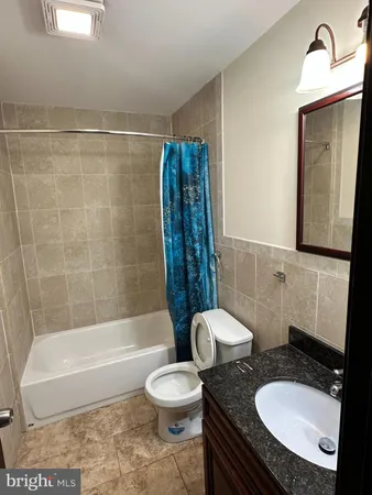 a bathroom with a granite countertop toilet a sink and bathtub