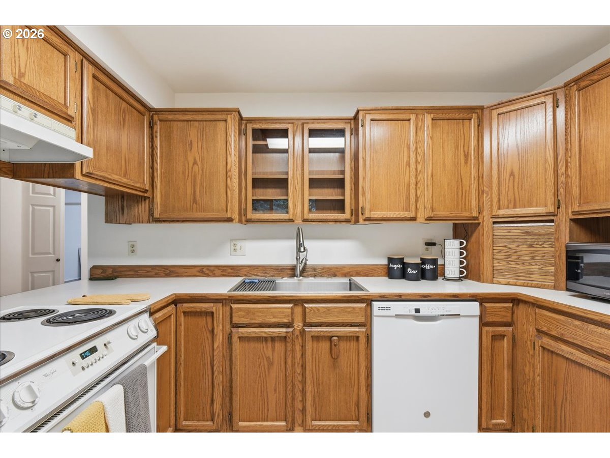 13102 Northwest 8th Way, Unit C Vancouver, WA 98685 - Photo 10 of 41 a kitchen with a sink a stove cabinets and a window