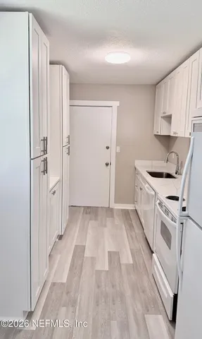 a kitchen with white cabinets and white appliances