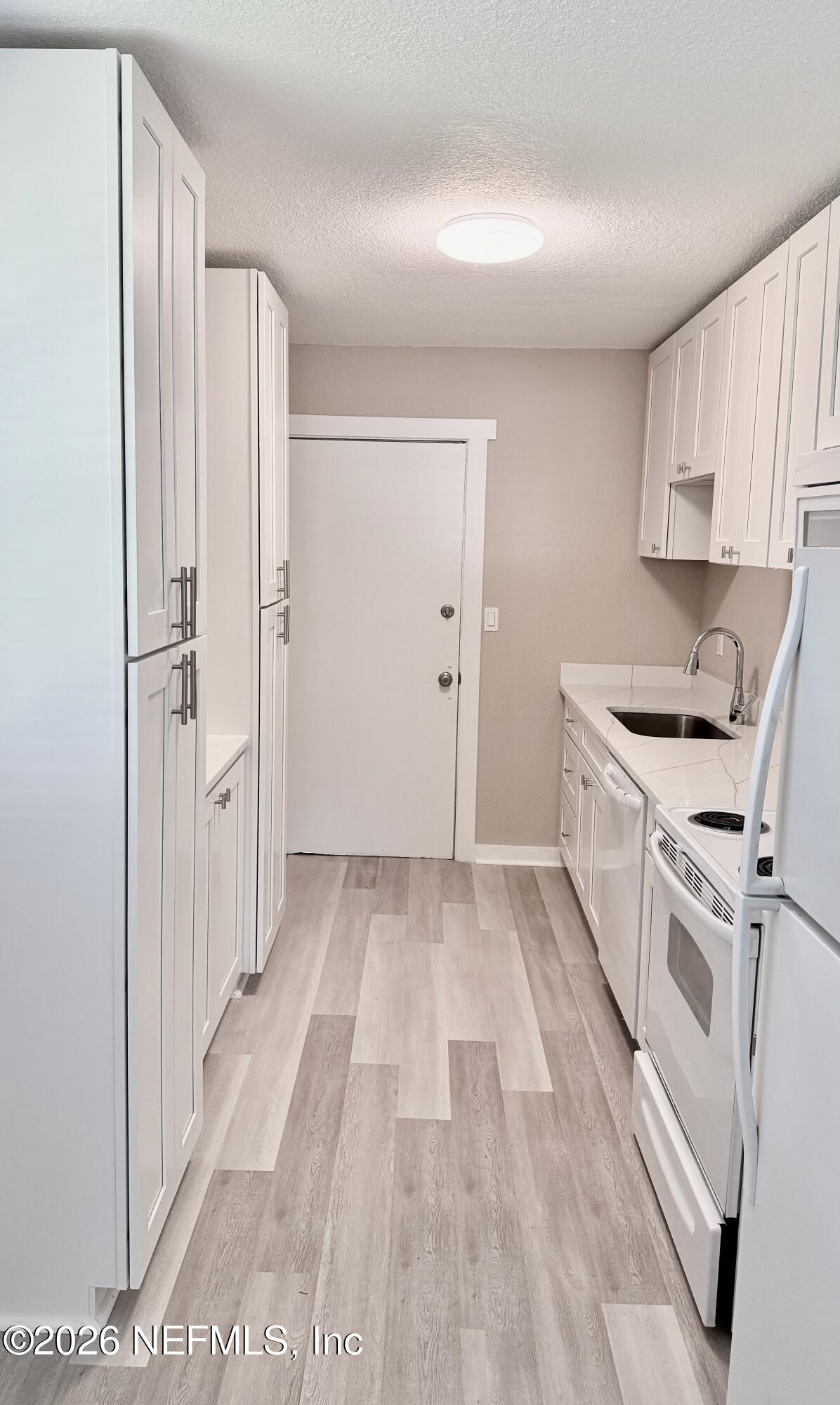 696 Kestner Road Atlantic Beach, FL 32233 - Photo 2 of 18 a kitchen with white cabinets and white appliances