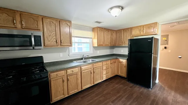 a kitchen with granite countertop white cabinets and refrigerator