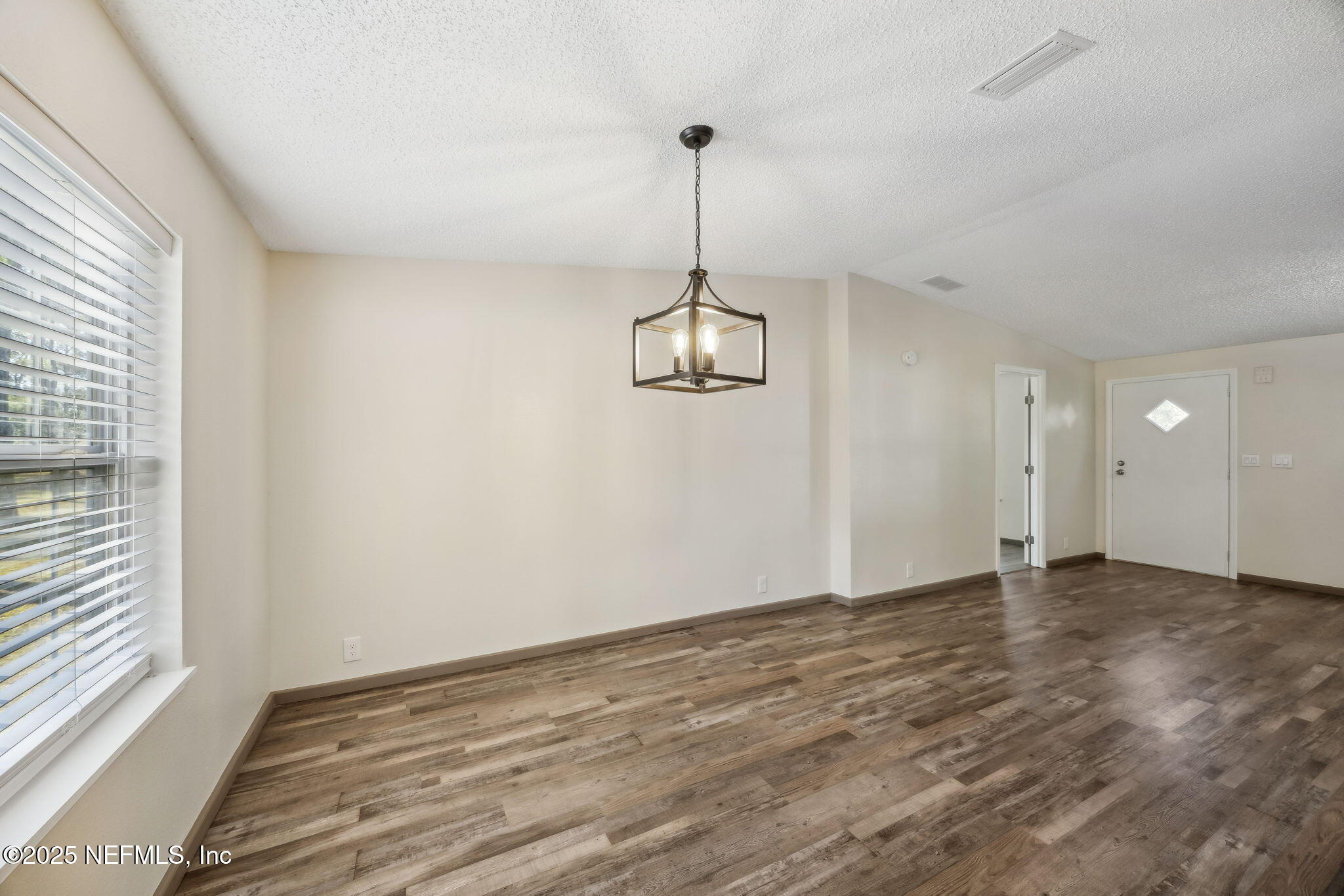 6034 Leona Padgett Road Jacksonville, FL 32234 - Photo 19 of 37 a view of an empty room with window and wooden floor