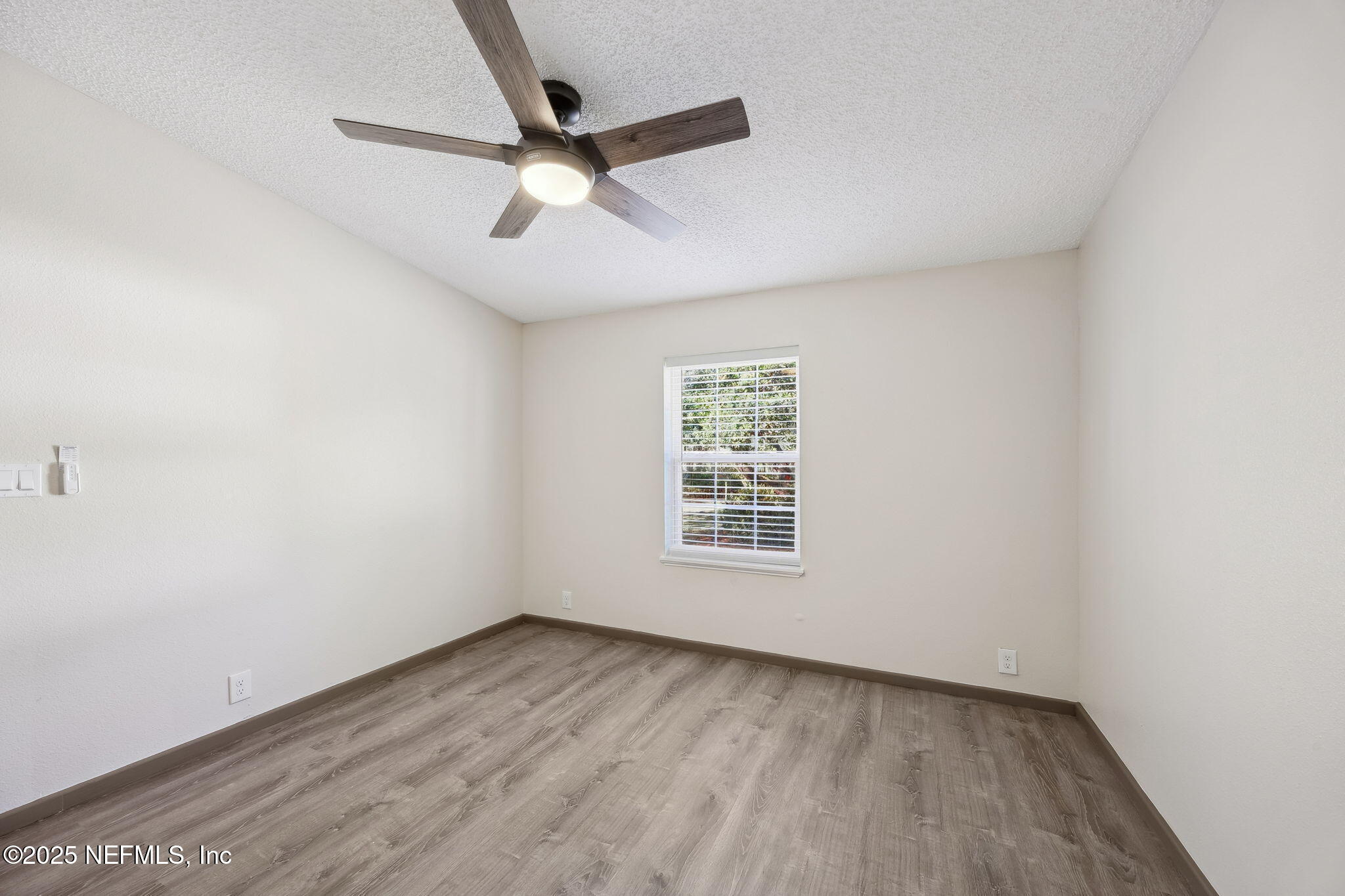 6034 Leona Padgett Road Jacksonville, FL 32234 - Photo 22 of 37 an empty room with wooden floor fan and windows