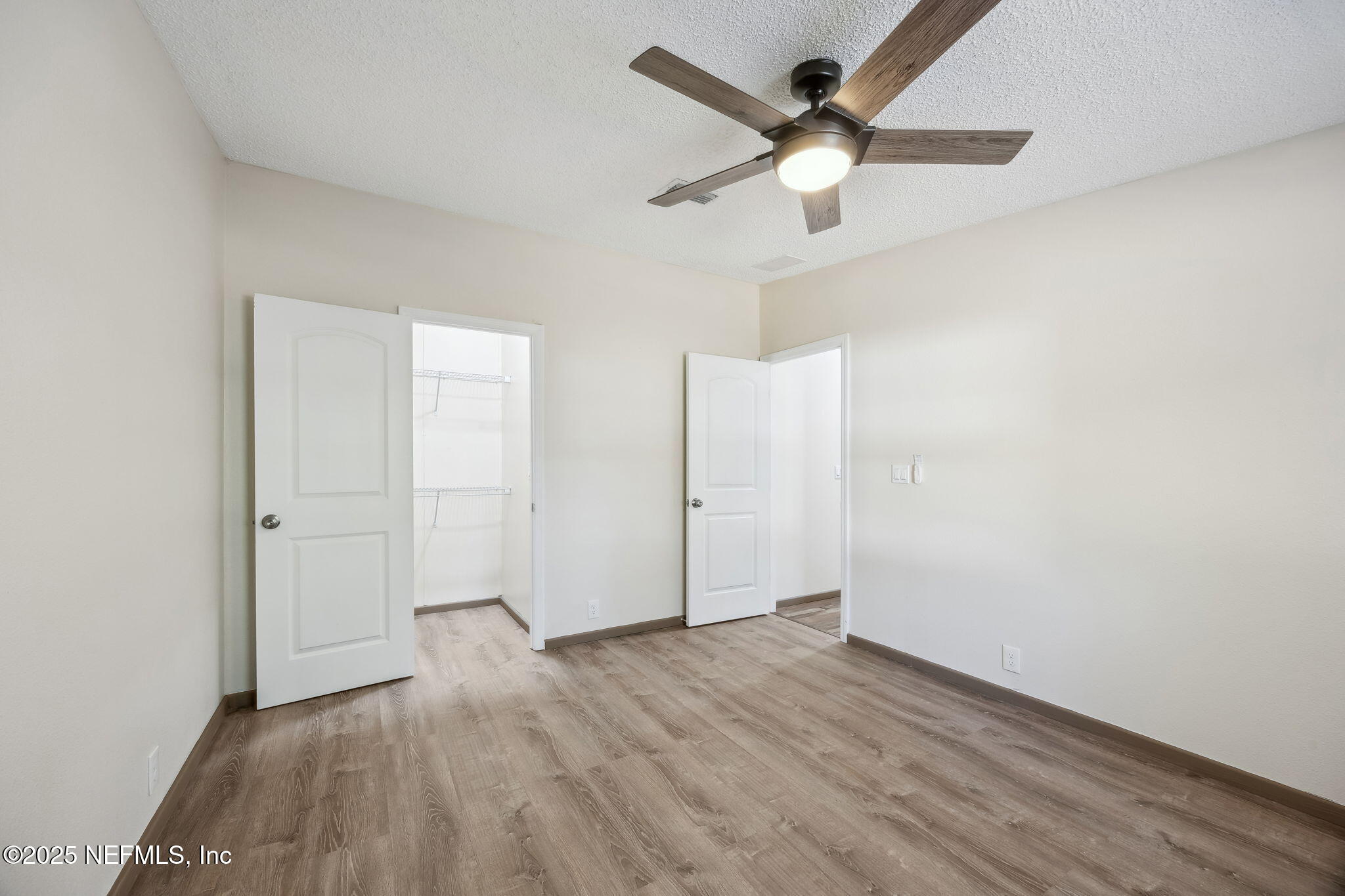 6034 Leona Padgett Road Jacksonville, FL 32234 - Photo 23 of 37 an empty room with wooden floor ceiling fan and window